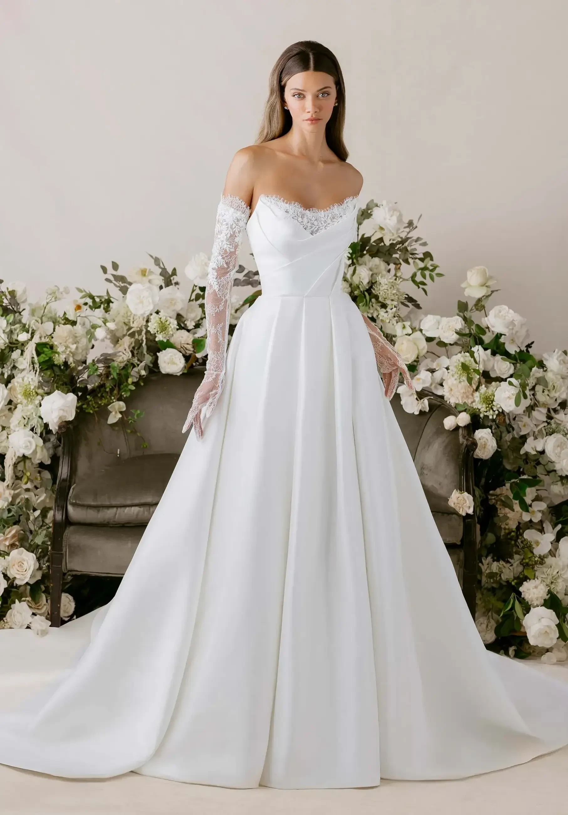 model is wearing an off the shoulder long sleeve ball gown